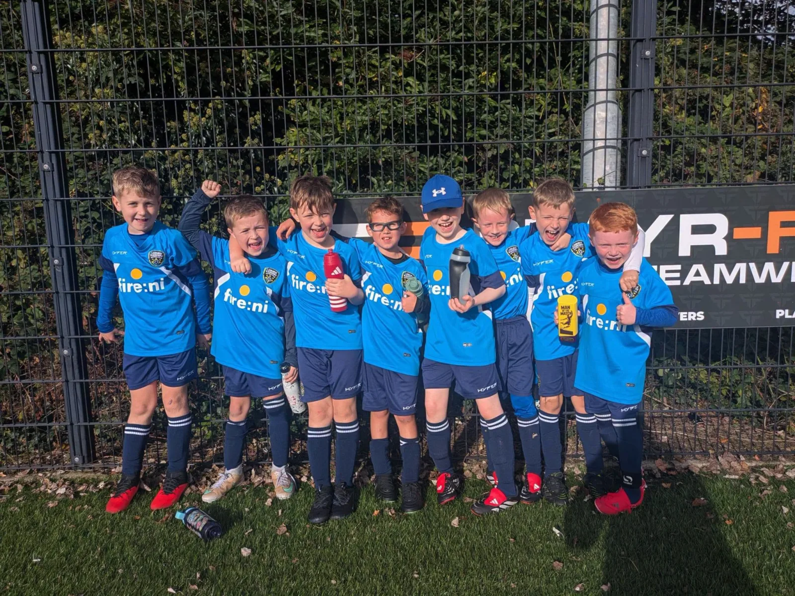 Young Lisburn Rangers boys smiling together in blue kits
